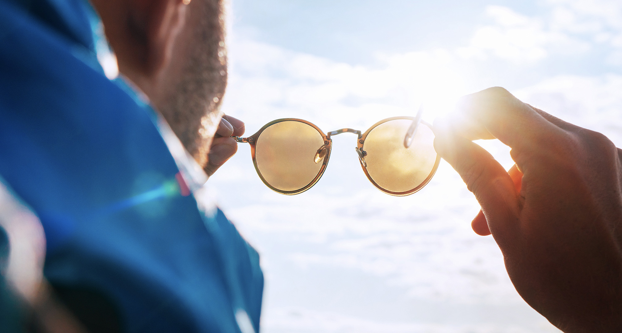 napszemüveget tart a nap felé